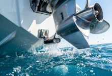 Transducer mounted on a boat transom for a fish finder tracking underwater depths.