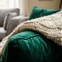 A cozy bed styled with plush blankets and layered pillows.